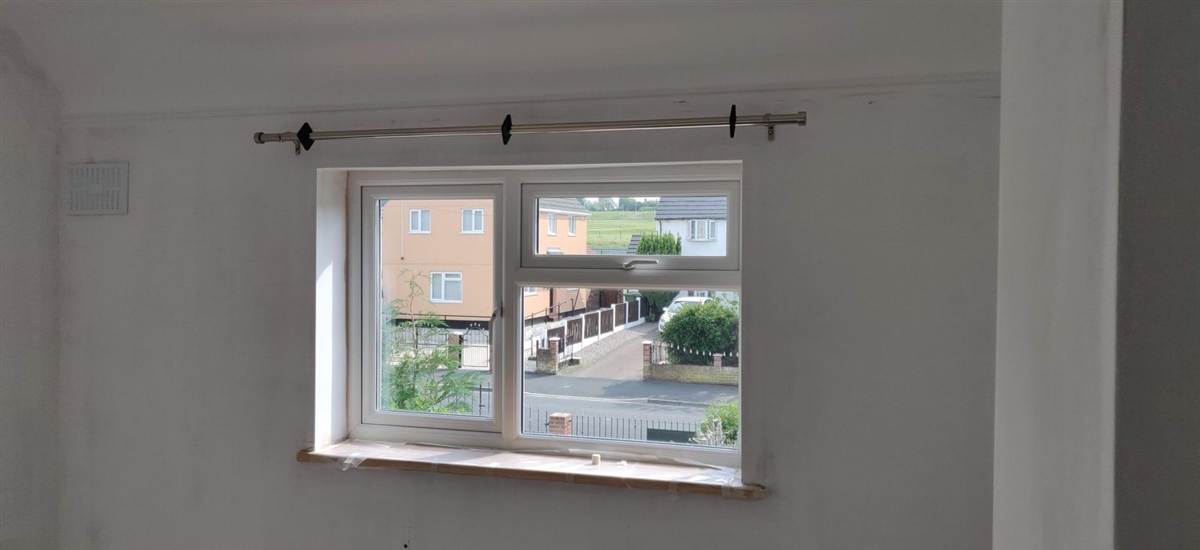 A curtain pole, fitted level and secure — brackets in the right place, ready to hang