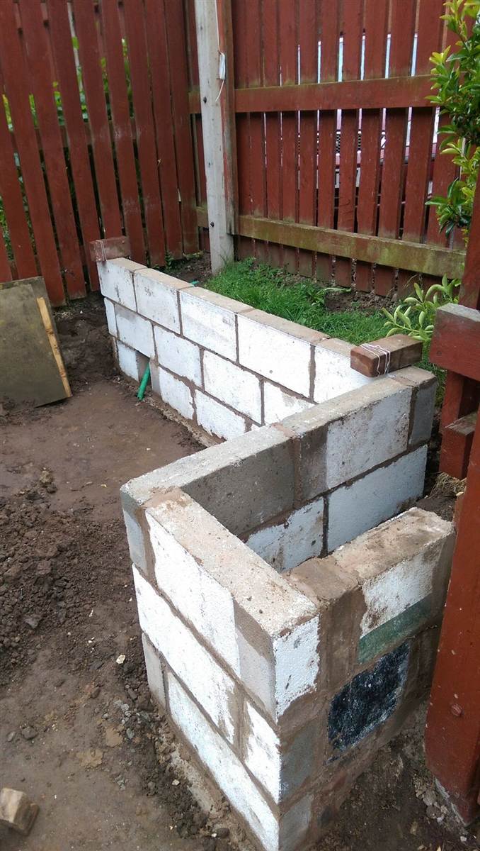 During — blockwork raised planters being built along the back fence
