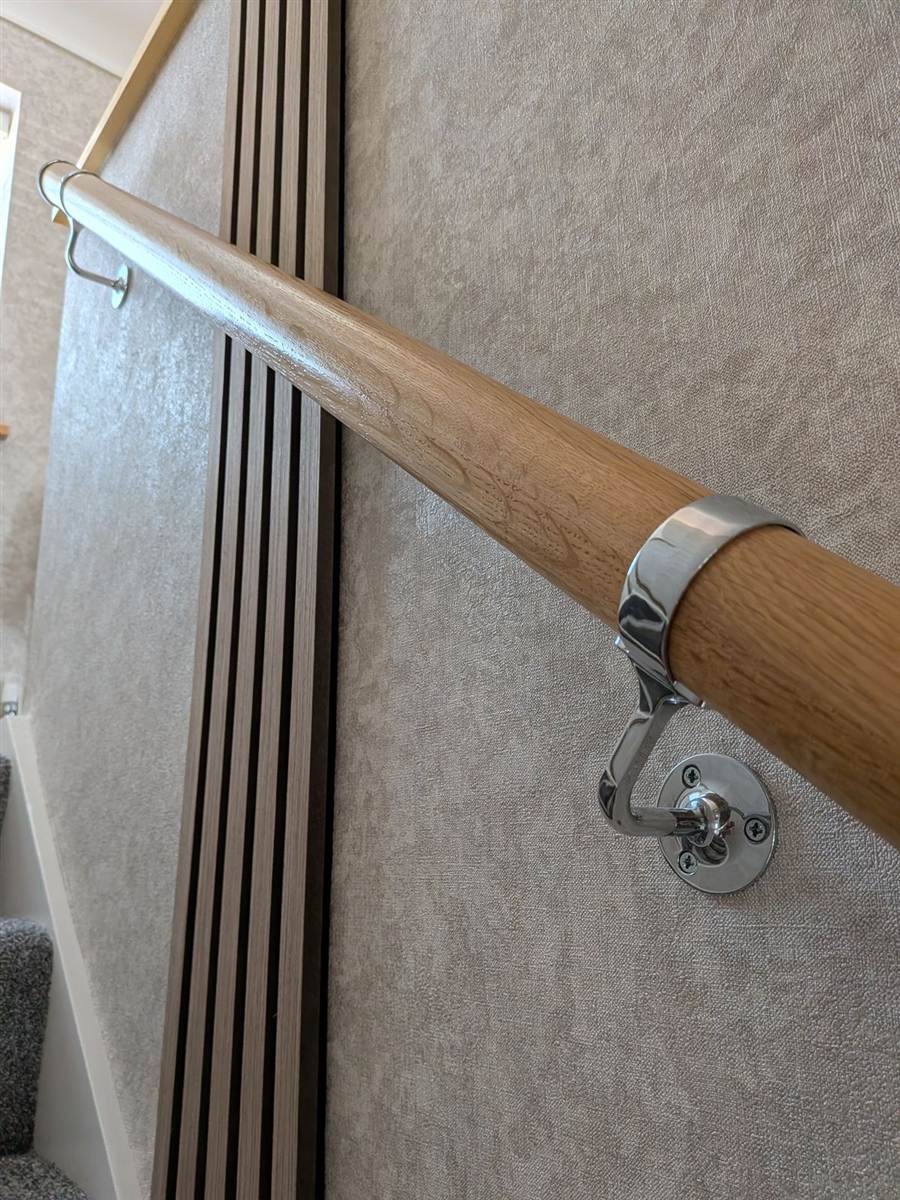 An oak handrail, fitted securely along the wall — something solid to hold on to where it is needed most