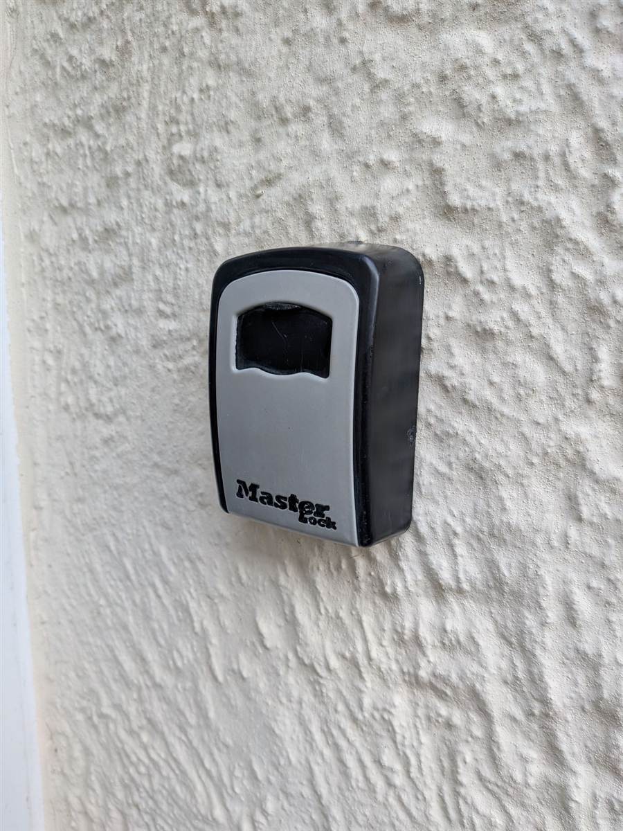 A key safe fitted securely to the wall — so a carer or family member can always get in when needed