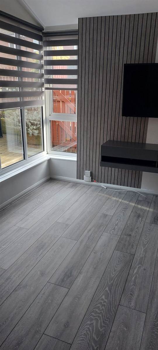 Grey oak laminate laid throughout — clean lines, neat edges, finished properly to the skirting
