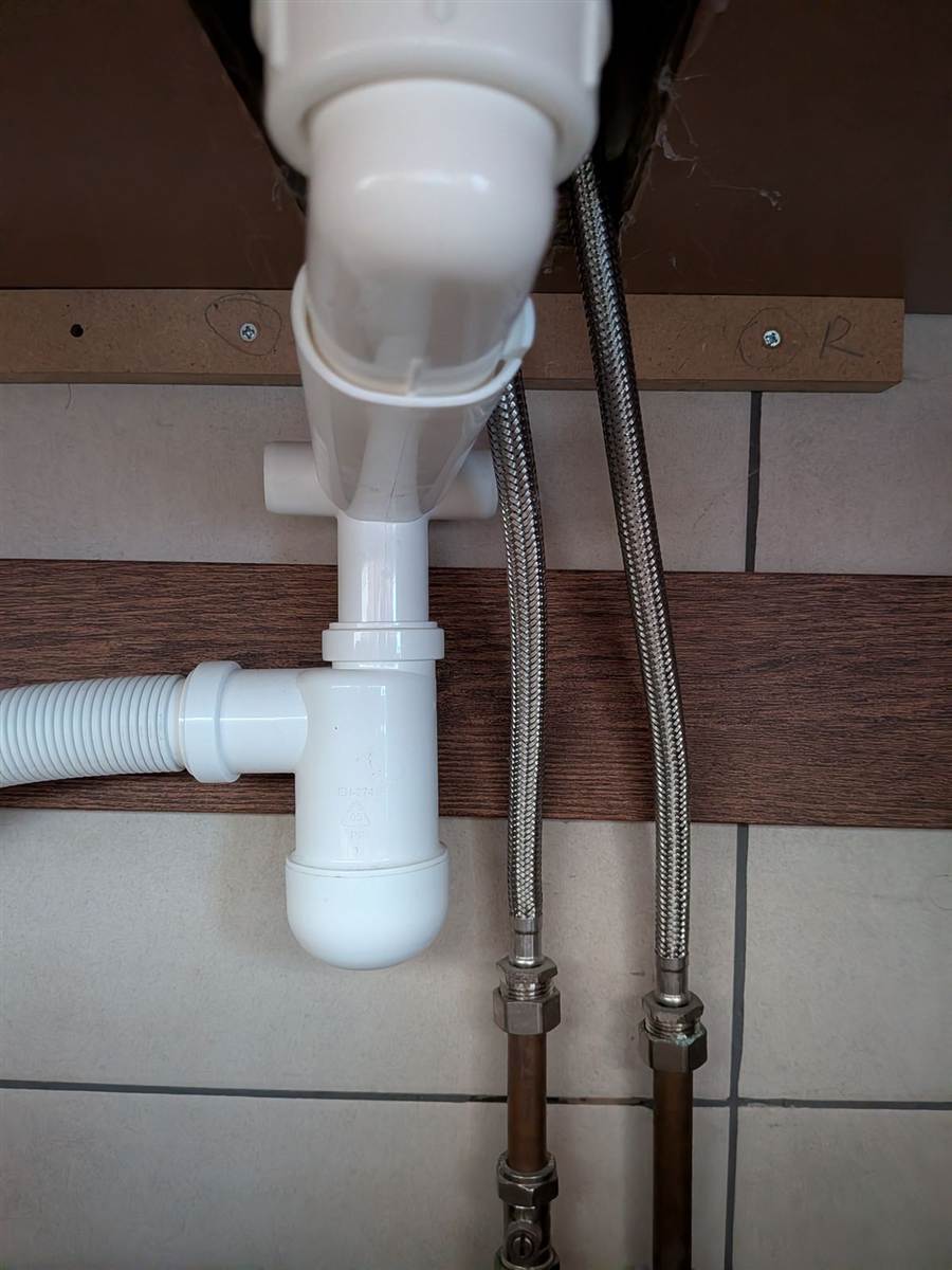 Sink waste and tap pipework renewed — clean connections under the basin