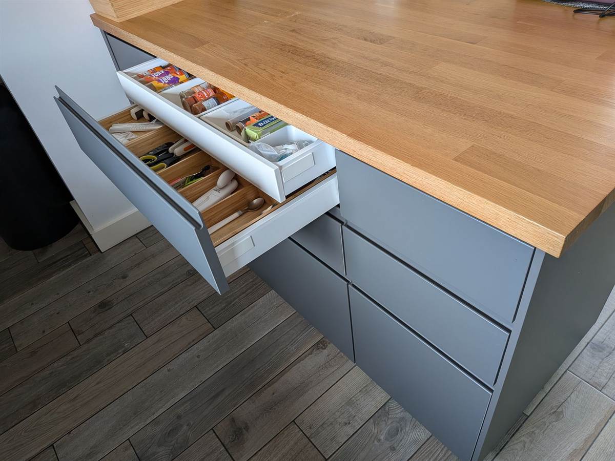 After — open drawer showing oak-lined interior with cutlery dividers beneath a solid oak worktop