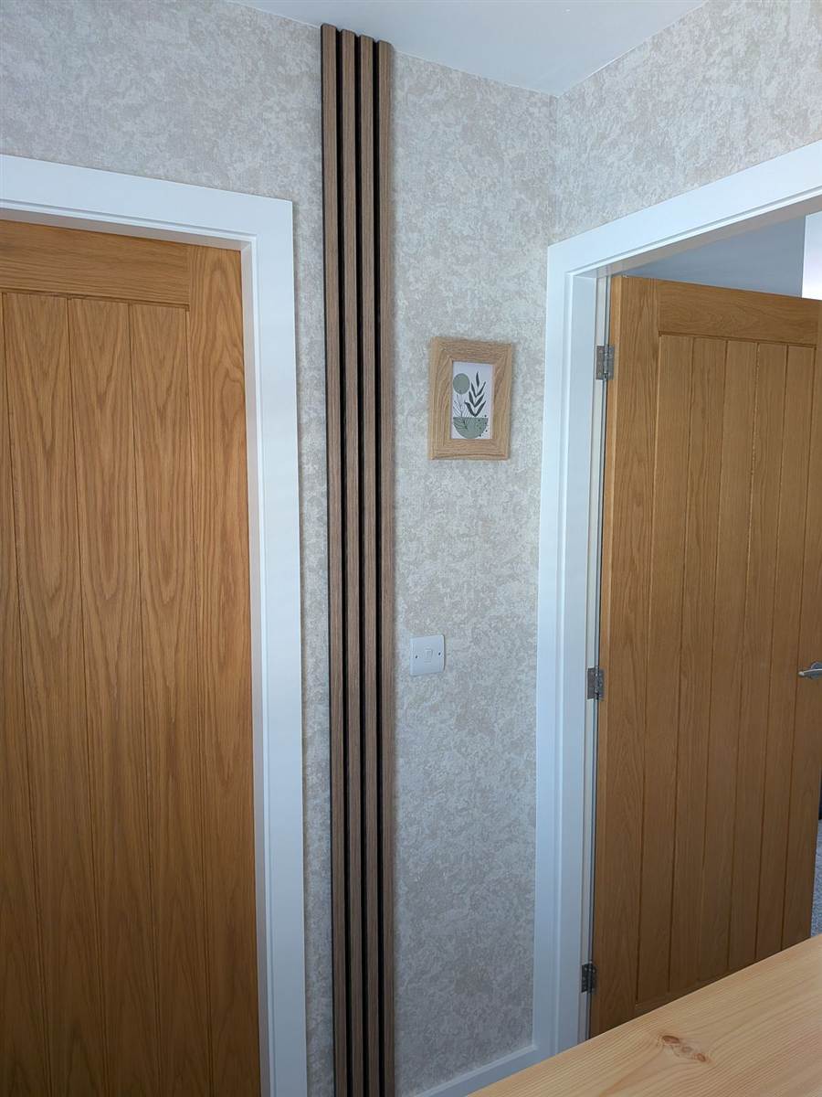 Oak slat panel fitted between two doors on the landing